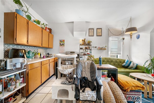 741 Mariposa St, Denver, CO 80204 - kitchen featuring light countertops, decorative backsplash, light tile patterned floors, and brown cabinets