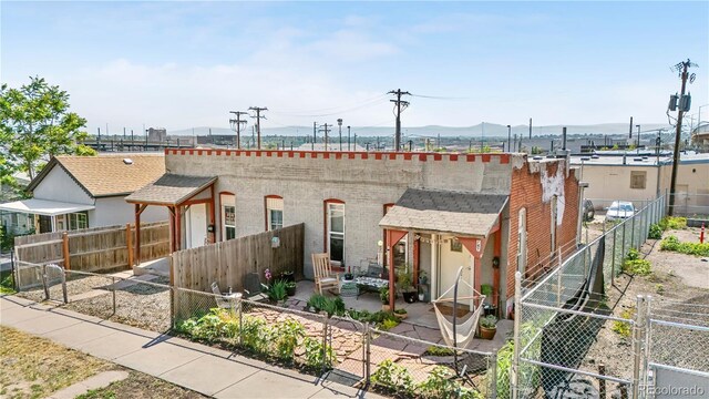 741 Mariposa St, Denver, CO 80204 - view of front of home with a patio area, a fenced backyard, and a mountain view