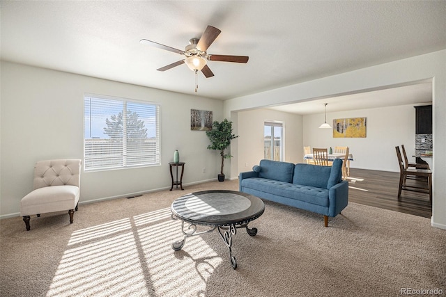 carpeted living room featuring ceiling fan and a wealth of natural light