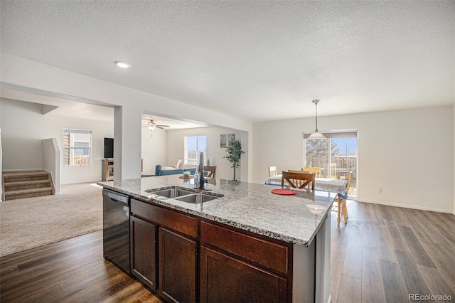 kitchen with a kitchen island with sink, sink, stainless steel dishwasher, a textured ceiling, and decorative light fixtures