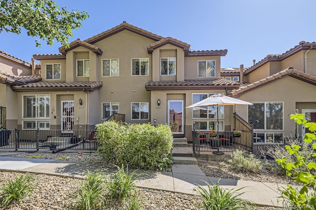 4555 S Auckland Ct, Aurora, CO 80015 - rear view of property featuring a tiled roof, a patio area, and stucco siding