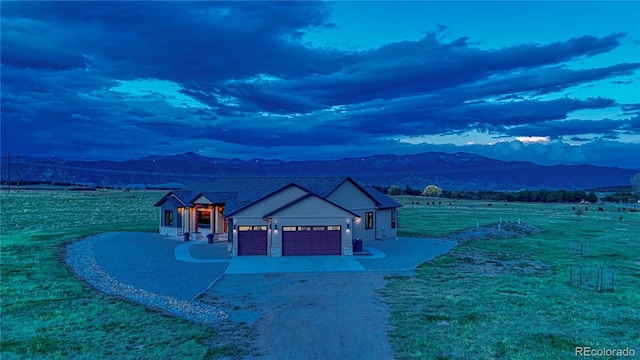 view of front of house featuring a front yard, a mountain view, driveway, and an attached garage