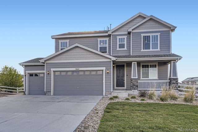 craftsman-style home featuring a garage, a porch, and driveway