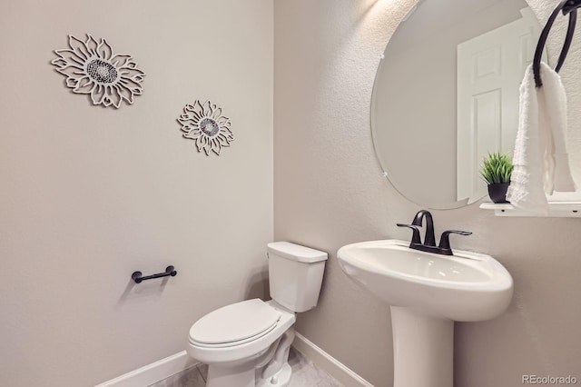 bathroom featuring baseboards and toilet
