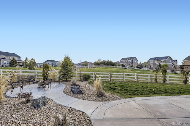view of yard with a residential view, a patio area, and an outdoor fire pit
