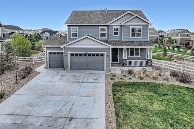 view of front of house featuring covered porch, driveway, an attached garage, and a residential view