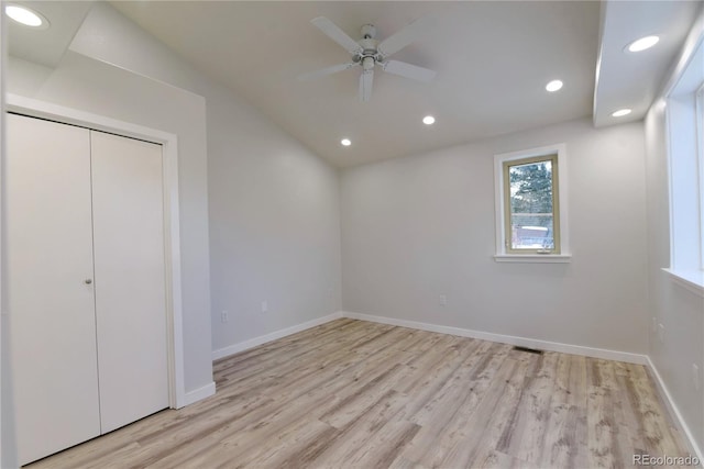 unfurnished bedroom featuring a closet, ceiling fan, light hardwood / wood-style flooring, and vaulted ceiling