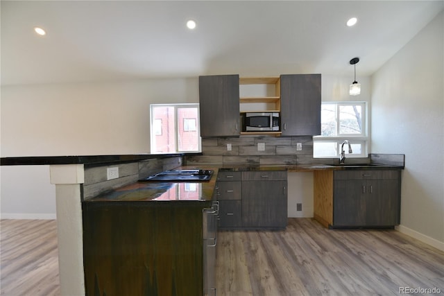 kitchen with pendant lighting, sink, decorative backsplash, light hardwood / wood-style floors, and dark brown cabinetry