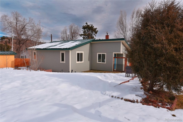 view of snow covered back of property