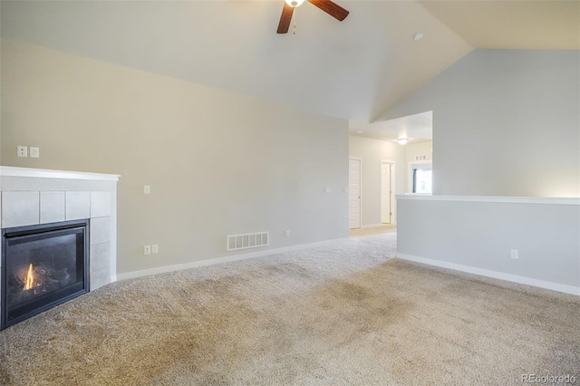 unfurnished living room with ceiling fan, light colored carpet, a tiled fireplace, and vaulted ceiling