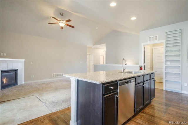 kitchen featuring ceiling fan, lofted ceiling, dishwasher, sink, and a kitchen island with sink