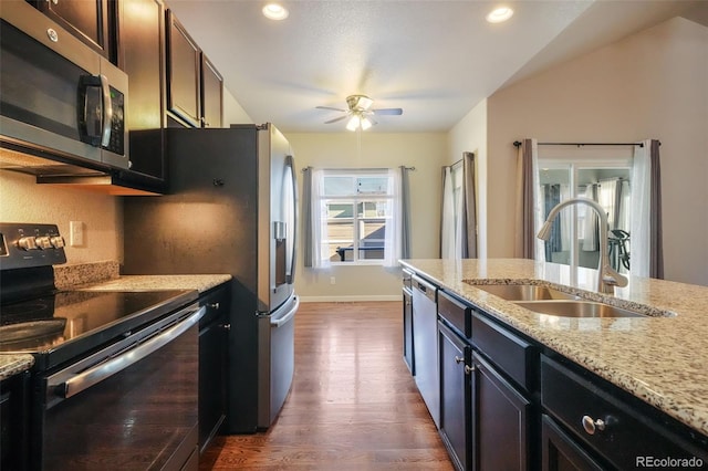 kitchen featuring ceiling fan, appliances with stainless steel finishes, dark wood-type flooring, light stone counters, and sink