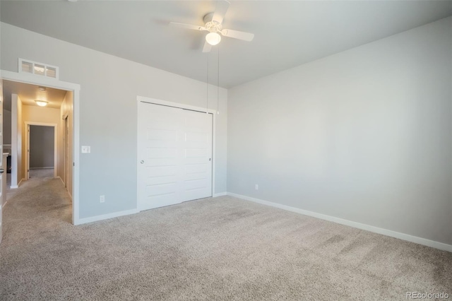 unfurnished bedroom with ceiling fan, a closet, and carpet floors