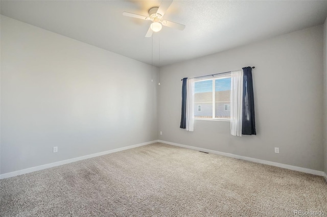 carpeted spare room featuring ceiling fan