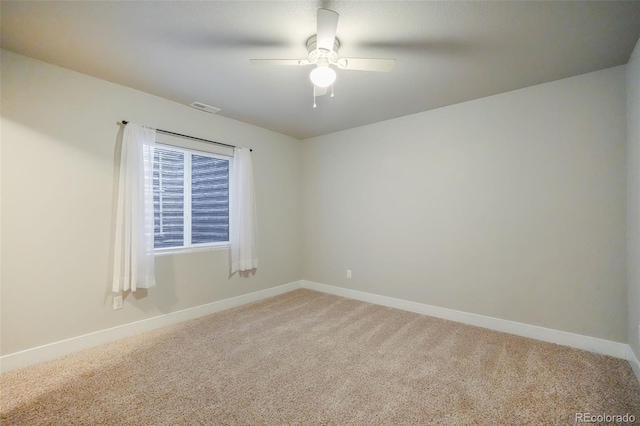 carpeted spare room with ceiling fan