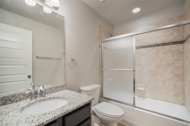 full bathroom with toilet, bath / shower combo with glass door, and vanity