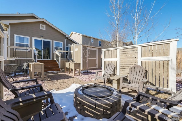 view of patio / terrace featuring a shed and a fire pit