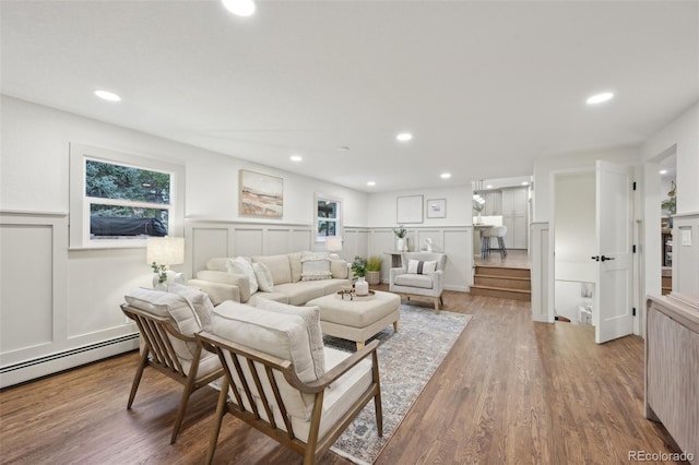 living room featuring a wainscoted wall, recessed lighting, a decorative wall, a healthy amount of sunlight, and wood finished floors