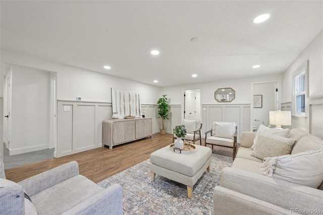 living room with recessed lighting, a wainscoted wall, and wood finished floors