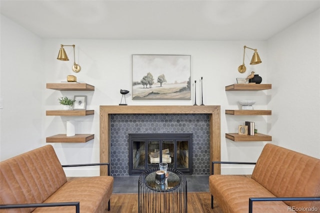 living area with a tiled fireplace and wood finished floors