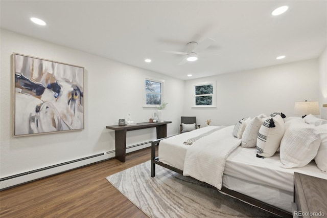 bedroom featuring a ceiling fan, recessed lighting, baseboard heating, and wood finished floors