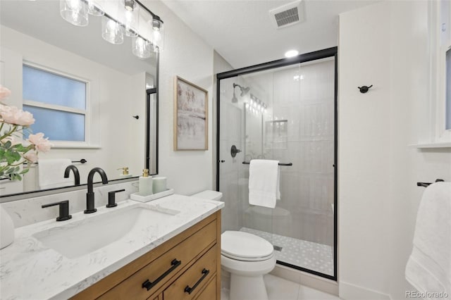 bathroom featuring toilet, a stall shower, vanity, and visible vents