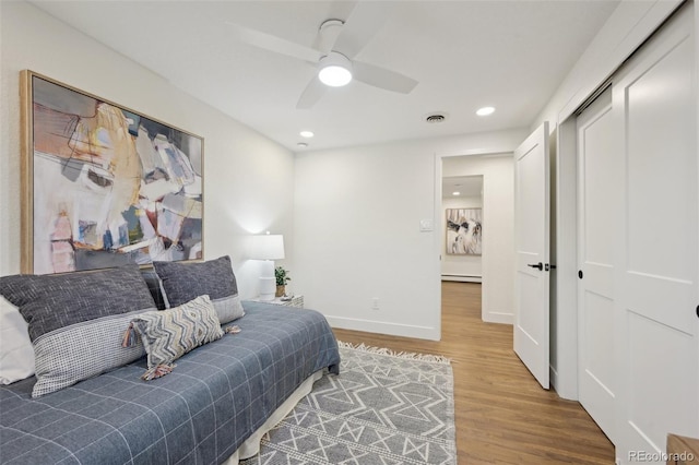 sitting room with baseboards, visible vents, a baseboard radiator, wood finished floors, and recessed lighting