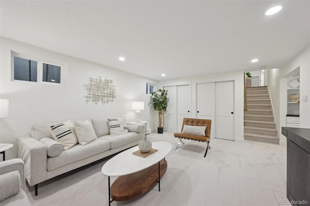 living room with stairs, light carpet, and recessed lighting