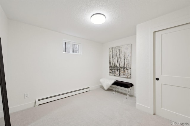 unfurnished room with a baseboard heating unit, baseboards, carpet floors, and a textured ceiling