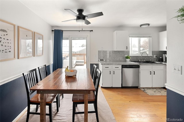 kitchen with white cabinetry, dishwasher, sink, and light hardwood / wood-style floors