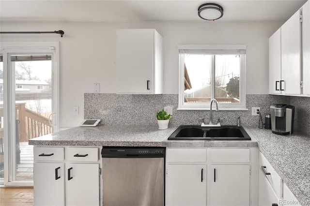 kitchen featuring white cabinetry, stainless steel dishwasher, sink, and tasteful backsplash