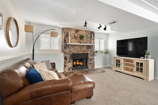 living room featuring a fireplace, track lighting, and carpet flooring