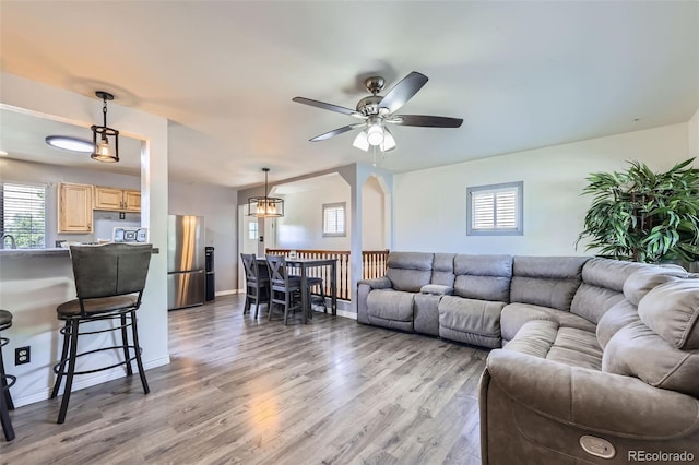 1166 W 98th Ave, Northglenn, CO 80260 - living room with light wood-style flooring, a ceiling fan, and a chandelier