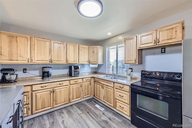 1166 W 98th Ave, Northglenn, CO 80260 - kitchen featuring black electric range oven, light brown cabinetry, light countertops, and light wood-style flooring