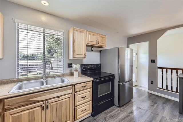 1166 W 98th Ave, Northglenn, CO 80260 - kitchen with black electric range, light brown cabinets, freestanding refrigerator, dark wood finished floors, and light countertops