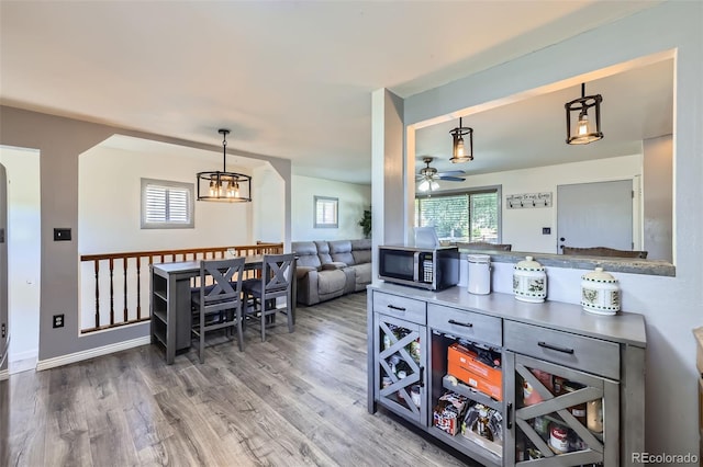 1166 W 98th Ave, Northglenn, CO 80260 - bar area featuring stainless steel microwave, a ceiling fan, wood finished floors, a chandelier, and decorative light fixtures
