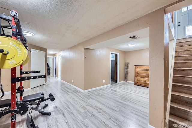 1166 W 98th Ave, Northglenn, CO 80260 - exercise room featuring a textured ceiling and wood finished floors