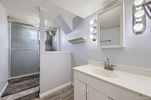 1166 W 98th Ave, Northglenn, CO 80260 - full bath featuring vanity, a shower with shower door, and wood finished floors