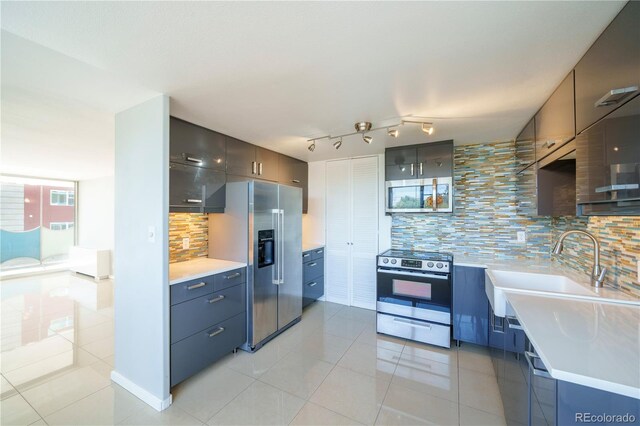 kitchen with decorative backsplash, appliances with stainless steel finishes, and light tile patterned floors