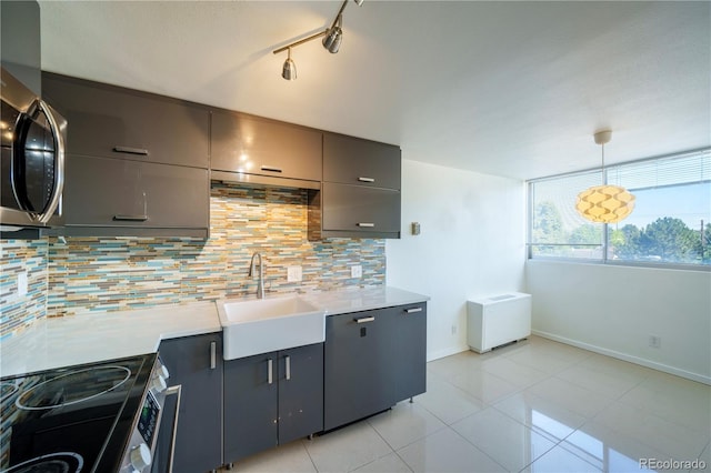 kitchen featuring hanging light fixtures, sink, rail lighting, and backsplash