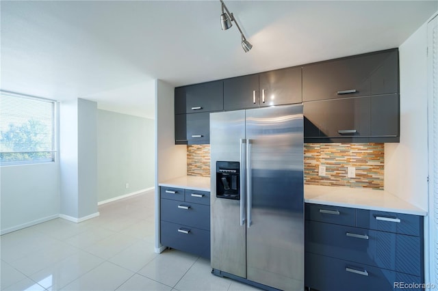 kitchen with decorative backsplash, light tile patterned floors, track lighting, and high end fridge