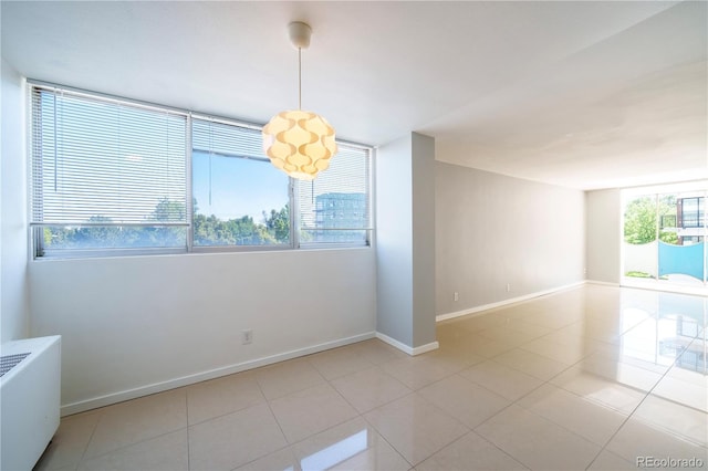 spare room with light tile patterned flooring and radiator heating unit