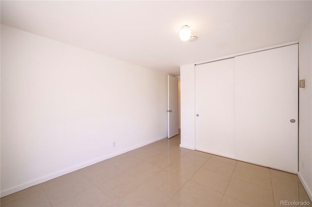 unfurnished bedroom featuring a closet and light tile patterned floors