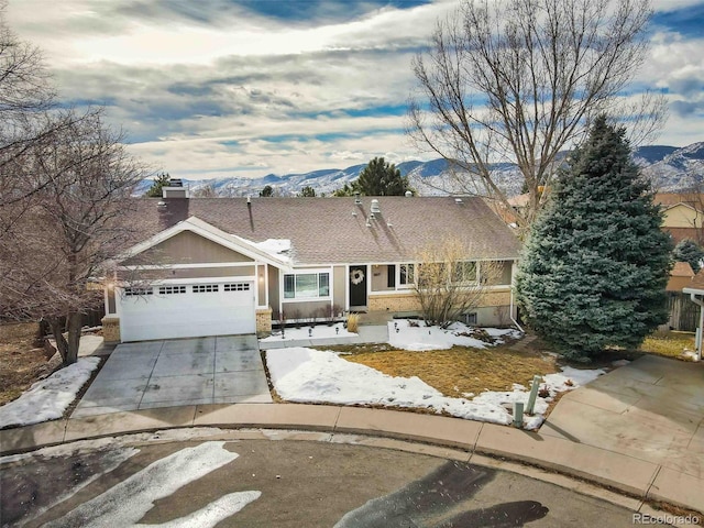 ranch-style home with a garage and a mountain view