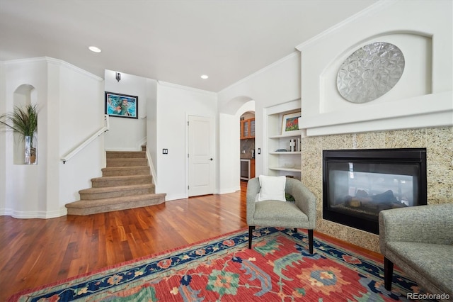 sitting room featuring recessed lighting, stairway, ornamental molding, wood finished floors, and a multi sided fireplace