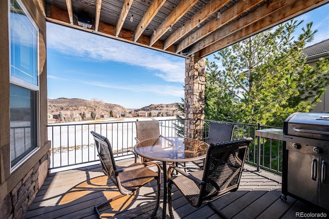 deck with outdoor dining area and a mountain view