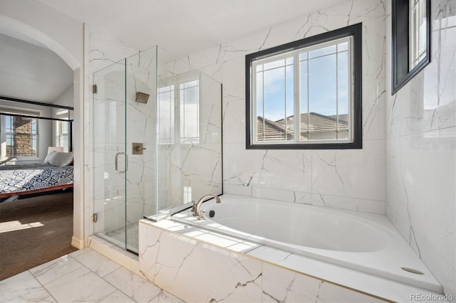 ensuite bathroom featuring a garden tub, ensuite bath, a marble finish shower, and a wealth of natural light