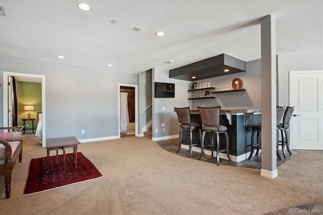 kitchen with recessed lighting, a breakfast bar, carpet flooring, baseboards, and dark cabinetry