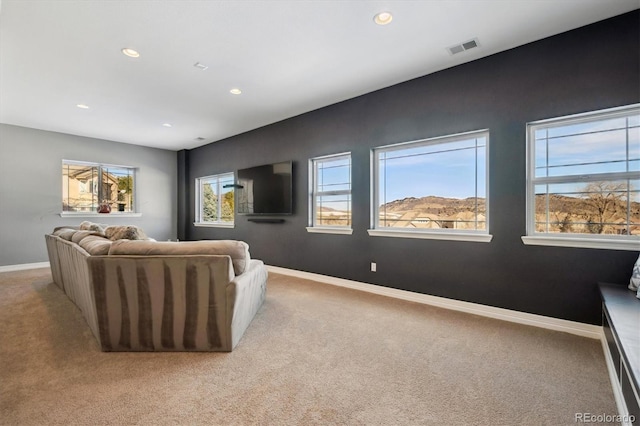 home theater room with light colored carpet, visible vents, and baseboards