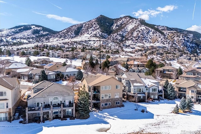 snowy aerial view featuring a residential view and a mountain view